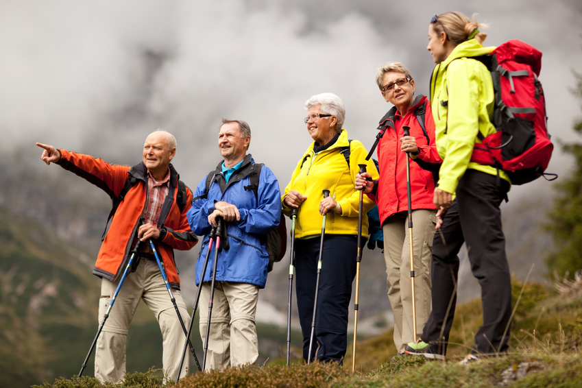 senior hiker pointing at something on misty mountain